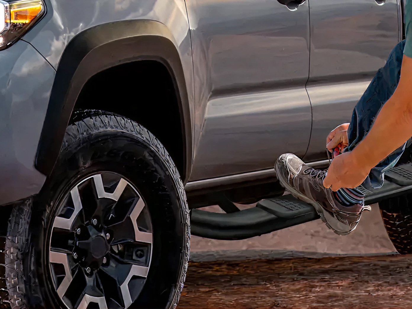Pickup truck with black running board step bars mounted along the cab