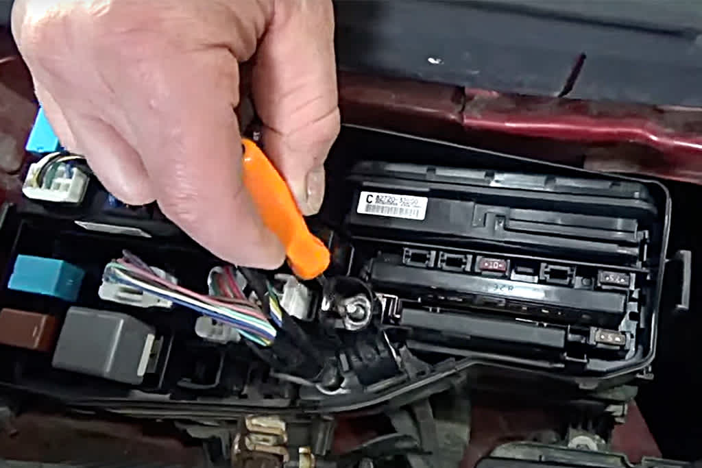 old mechanic in blue attire performs inspection on car